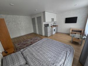 a large bedroom with a bed and a kitchen at В Центре Экибастуза in Ekibastuz