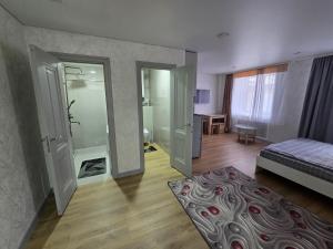 a room with a bedroom with a bed and a bathroom at В Центре Экибастуза in Ekibastuz