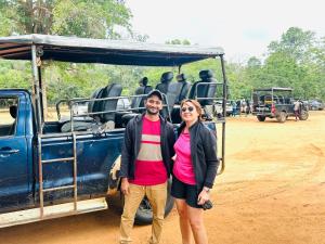 a man and woman standing in front of a blue truck at Just Inn in Puttalam