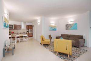 a living room and kitchen with a couch and chairs at White House – Villa con Jacuzzi e Posto Auto in Otranto