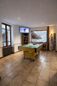 a large room with a pool table and a tv at Splendid ski-in,ski-out historical chalet! in La Lechere