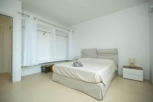 a white bedroom with a bed and a window at White House – Villa con Jacuzzi e Posto Auto in Otranto