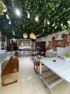 a room with tables and chairs and plants on the ceilings at Candra Dewi Yogyakarta in Yogyakarta