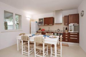 a kitchen with a white table and chairs in it at White House – Villa con Jacuzzi e Posto Auto in Otranto +32 photos
