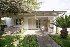 a porch of a house with a palm tree at White House – Villa con Jacuzzi e Posto Auto in Otranto