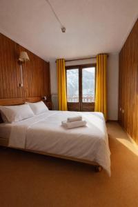 a bedroom with a large white bed with yellow curtains at Splendid ski-in,ski-out historical chalet! in La Lechere