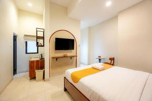 a bedroom with a bed and a flat screen tv at Cove Chara in Jimbaran +20 photos