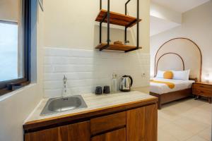 a kitchen with a sink and a bed in a room at Cove Chara in Jimbaran