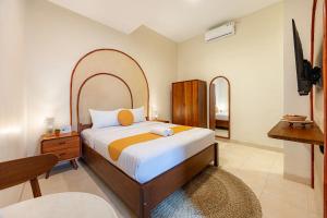 a bedroom with a large bed and a tv at Cove Chara in Jimbaran