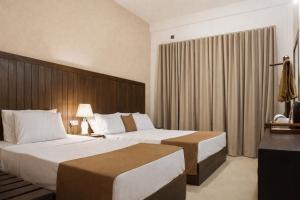 a hotel room with two beds and a window at Jackhill Hiriketiya in Dickwella