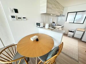 a kitchen with a wooden table and chairs in a room at Lapita Resort in Sakai
