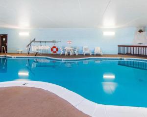 a large blue swimming pool with a table and chairs at Quality Inn Maysville in Maysville