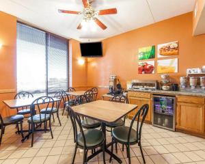 a dining room with tables and chairs and a kitchen at Quality Inn Maysville in Maysville