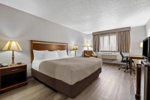 a hotel room with a bed and a desk at Quality Inn near Monument Health Rapid City Hospital in Rapid City +32 photos