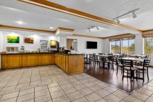 a large room with a bar and tables and chairs at Quality Inn near Monument Health Rapid City Hospital in Rapid City