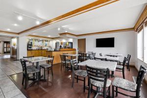 a restaurant with tables and chairs and a kitchen at Quality Inn near Monument Health Rapid City Hospital in Rapid City