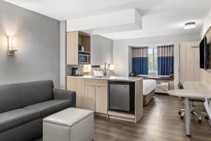 a hotel room with a couch and a bed and a table at Quality Inn & Suites Nashville - Bellevue in Nashville