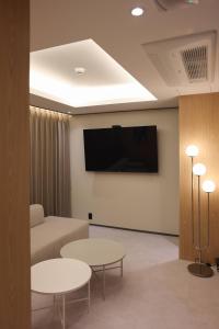 a living room with two tables and a flat screen tv at Incheon No25 Hotel Seogu in Incheon +31 photos