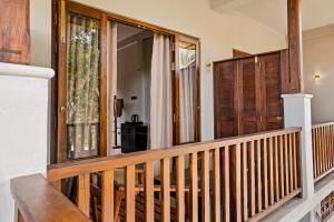 a porch with wooden railing and a sliding glass door at Jackhill Hiriketiya in Dickwella