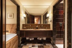a bathroom with a tub and a large mirror at Hotel Saint Roch in Courchevel