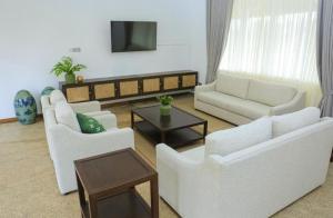 ein Wohnzimmer mit weißen Möbeln und einem Fernseher in der Unterkunft Yatra Negambo in Katunayaka