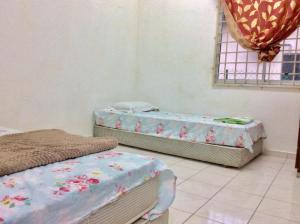 a room with two beds and a window at IMADUDDEEN Homestay in Kampong Bukit Kuang
