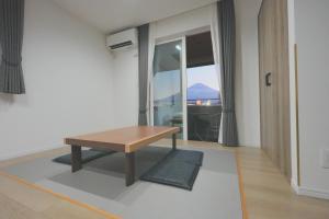 a room with a wooden table and a window at Hostel labeek in Fujikawaguchiko