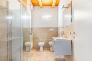 a bathroom with a toilet and a sink and a shower at Luxury Lakeview Loft in Baveno +7 photos