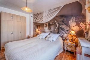 a bedroom with a large bed with a face on the wall at La douce echappée in Trèbes +33 photos