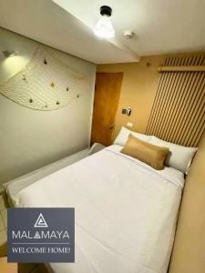 a bedroom with a large white bed in a room at Malamaya Staycation in Manila