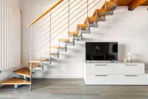 a living room with a tv and a staircase at Luxury Lakeview Loft in Baveno