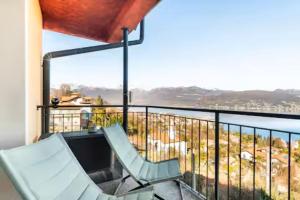 two chairs on a balcony with a view of the water at Luxury Lakeview Loft in Baveno