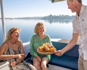 a man holding a plate of food on a boat at Waterscape Floating Apartment in Augusta +14 photos