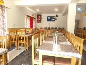 a dining room with wooden tables and chairs at The Snowpeak Hunder in Hundar