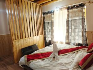 a bedroom with a bed with a towel on it at The Snowpeak Hunder in Hundar