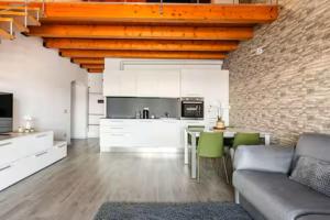 a kitchen and living room with a couch and a table at Luxury Lakeview Loft in Baveno