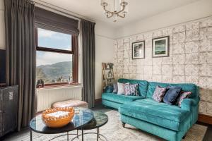 a living room with a blue couch and a table at Helter Skelter Matlock in Matlock