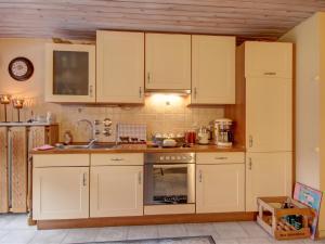 a kitchen with white cabinets and a sink at Gästehaus Barbara Schwaiger - Chiemgau Karte in Inzell