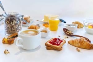 a table with a cup of coffee and breakfast foods at easyHotel Valencia Ciutat Vella in Valencia