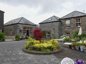 a brick house with plants in a courtyard at Coach House in Portlaoise