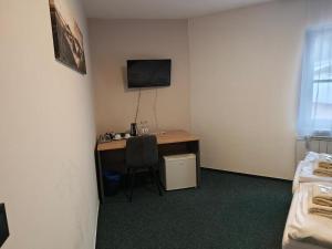 a room with a desk with a computer and a television at HOTEL Tyrapol - izby in Oravská Lesná