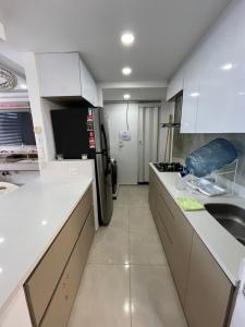a kitchen with white counters and a refrigerator at El encanto de Cartagena in Cartagena de Indias