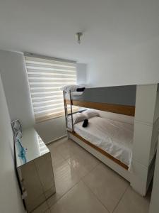a small room with a bunk bed with a window at El encanto de Cartagena in Cartagena de Indias