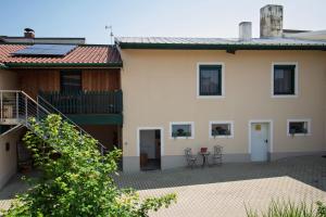 a house with a courtyard and a table and chairs at Rebenhof Schwalm in Herrnbaumgarten
