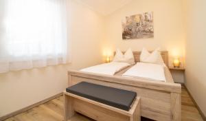 a bedroom with a large bed with white sheets at Rebenhof Schwalm in Herrnbaumgarten