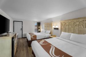 a hotel room with two beds and a flat screen tv at Rodeway Inn Llano in Llano +45 photos