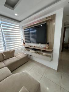 a living room with a couch and a flat screen tv at El encanto de Cartagena in Cartagena de Indias