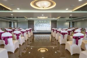 a conference room with rows of chairs with purple bows at Hotel Parkelite in Gannavaram