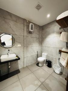 a bathroom with a sink and a toilet and a mirror at Dhanrains La Rocha in Patnem