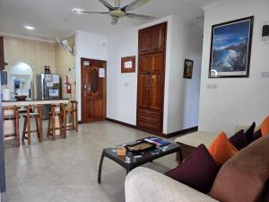 a living room with a couch and a table at The Drake Seaside Apartment in Bel Ombre